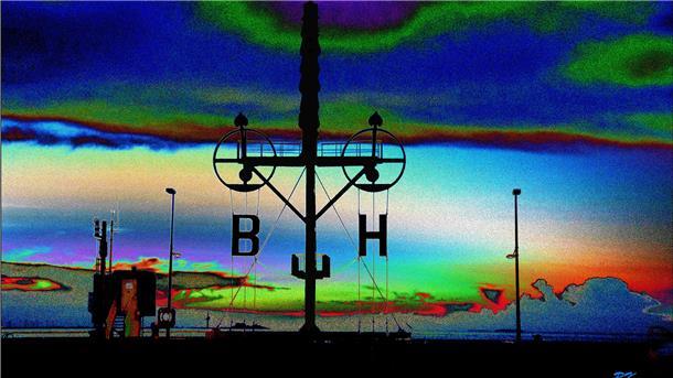 Hinter dem historischen Wasserstandsanzeiger wetterleuchtet der Himmel in Blau, Grün und ein bisschen Rot. Rainer Korsa zeigt die vertraute Umgebung auf seinem Foto so, dass hier auch ein Science-Fiction-Film spielen könnte.