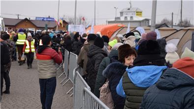 Hoffnung trotz des Leids: Eine geflüchtete Ukrainerin steht mit Hunderten anderen in einer Schlange und wartet darauf, einen der Shuttlebusse zu besteigen, die sie in die Sammelzentren im Umland bringen.