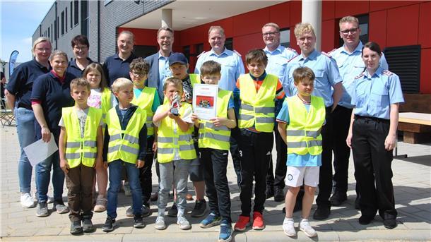 Holten den Sieg bei den „Spielen ohne Grenzen" in Zeven: die Kinderfeuerwehr aus Seedorf. Mit den Kindern freuen sich die Betreuer, Feuerwehrkameraden und Samtgemeindebürgermeister Henning Fricke.