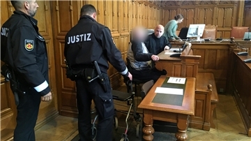 Justizbeamte neben der Anklagebank. 