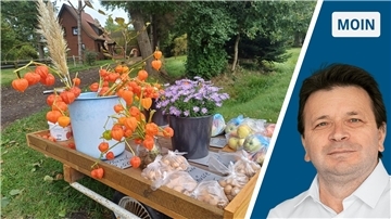 Links: Blumen und Äpfel auf einem Bollerwagen. Rechts: NZ-Reporter Ismail Kul.