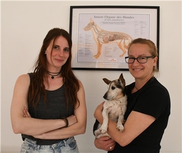 Zwei Frauen lächeln, die Frau rechts hält einen Hund auf ihren Armen. Im Gesundheitszentrum für Hunde: Sahra-Lena Jaudzin (links) und Anja Aßhauer mit Hündin Lili, der Assistentin auf vier Pfoten.