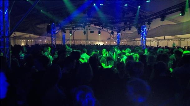 Das Foto zeigt Leute beim Tanzen im Festzelt. 