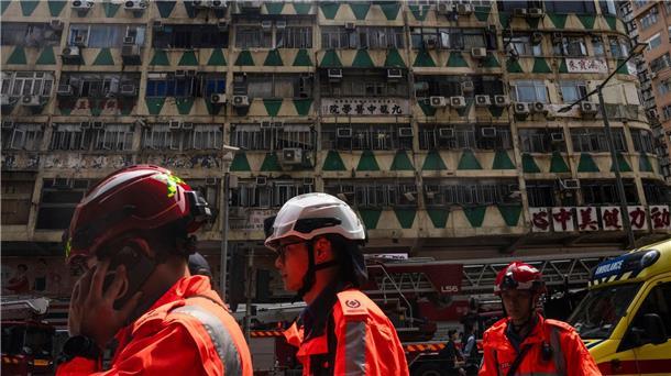 Mehrere Tote bei Hochhausbrand in Hongkong Im Hintergrund ist das ausgebrannte Hochhaus in Hongkong zu sehen - bei der Feuerwehr waren zahlreiche Hilferufe eingegangen.