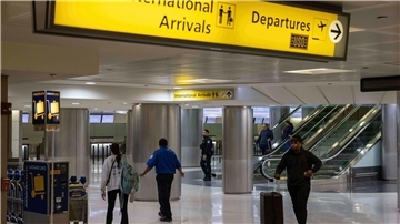 Menschen mit Koffern gehen durch das internationale Terminal des Newark Liberty International Airport.