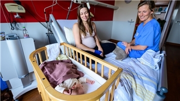 Im Klinikum Lüneburg werden Verena Ahrens und ihre wenige Tage alte Tochter von Hebamme Franziska Pfeil (r) betreut. Pfeil hat die erste Geburt im neu eröffneten hebammengeleiteten Kreißsaal im Klinikum Lüneburg betreut.