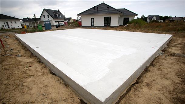 Die Grundplatte für ein neues Einfamilienhaus liegt in einem Neubaugebiet. 