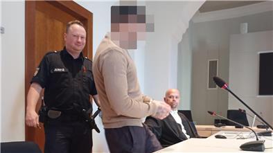 Angeklagter wird von Justizbeamten in den Saal geführt.