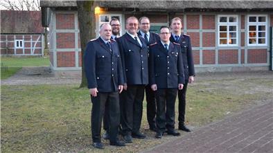 Ehrenamt mit Zukunft: Diese Feuerwehrleute sind offiziell in Dienst gestellt Sechs Feuerwehrleute stehen in festlicher Uniform vor einem norddeutschen Fachwerkhaus.