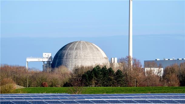 Das bereits stillgelegte und seit 2018 im Rückbau befindliche Kernkraftwerk Unterweser (KKU) steht hinter Photovoltaikanlagen eines Solarparks.