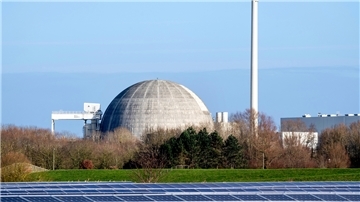 Das bereits stillgelegte und seit 2018 im Rückbau befindliche Kernkraftwerk Unterweser (KKU) steht hinter Photovoltaikanlagen eines Solarparks.