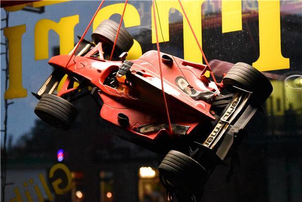 Im Schaufenster der Ferrari-Kneipe hängt ein Formel-1-Auto.