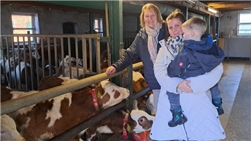 Britta Grollimund vom Landvolk und Landwirtin Annkathrin Thalmann mit Sohn im Stall mit den Kälbern. 