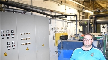 Mann steht in einem Keller mit viel Technik