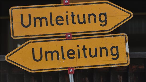 Zwei Umleitungsschilder zeigen nach links und rechts.