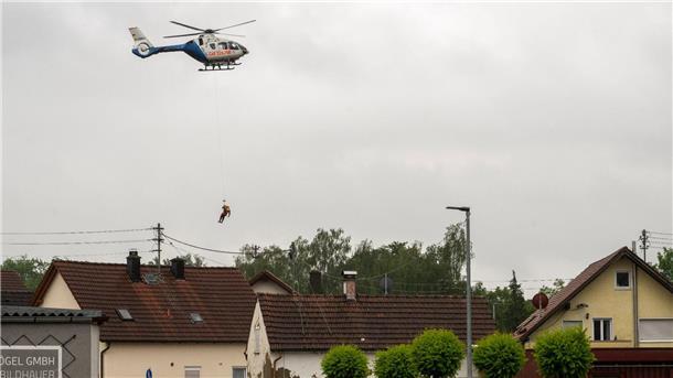 Lage zugespitzt: Menschen aus überfluteten Häusern gerettet In Babenhausen wird ein Wasserretter aus einem Polizeihubschrauber abgeseilt.