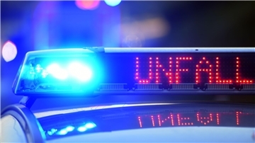 Bild von einem Polizeiauto mit eingeschaltetem Blaulicht und dem Schriftzug "Unfall"