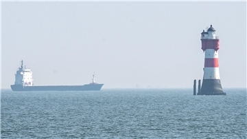 In der Außenweser fährt ein Schiff am Leuchtturm Roter Sand vorbei. Steht das berühmte maritime Wahrzeichen bald in Fedderwardersiel?