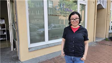 Marie hilft: Unterstützung für Sexarbeiterinnen in Bremerhaven Eine Frau mit schwarzer Leinenbluse und Brille vor einem Schaufenster auf dem "Marie - Beratungstelle" steht.