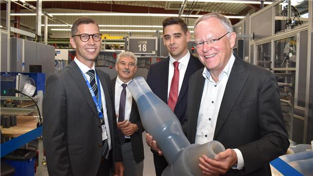 Eine Gruppe von Männern in einem Industriebetrieb mit Ministerpräsident Stephan Weil