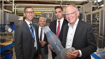 Eine Gruppe von Männern in einem Industriebetrieb mit Ministerpräsident Stephan Weil