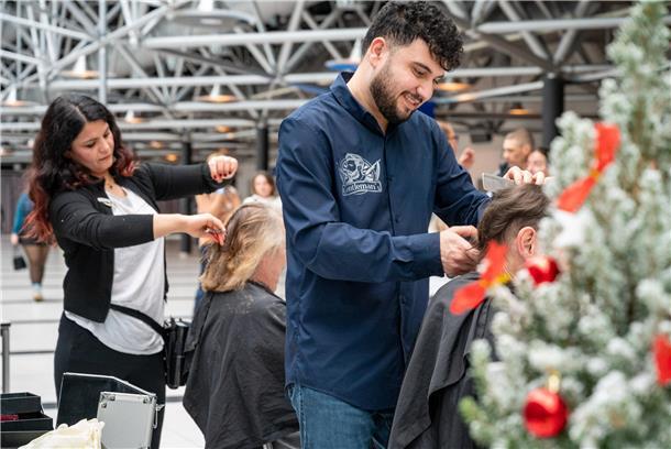 In der Stadthalle wird wieder zur Weihnachtszeit für bedürftige Menschen gesorgt. Dalal Hasso (li.) macht mit ihren Verwandten Farhan Hesso (re.) und Nessim Hesso einen guten Schnitt.