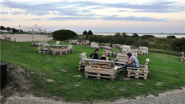 In der Strandbar kann man sich leger hinsetzen und den Blick auf die Weser genießen. Stärken kann man sich mit Angeboten vom Eisstand und Kiosk.
