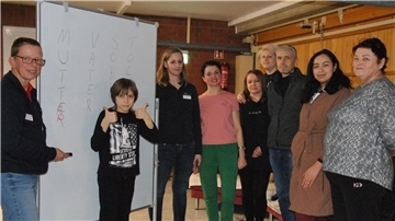 In der Zevener Notunterkunft wird Deutsch gelernt: Die DRK-Mitarbeiterinnen Claudia Oerding (links) und Melanie Erdrich üben mit den Ukrainern im Aufenthaltsraum in der Turnhalle.