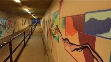 Ein Tunnel mit mehreren Graffiti an den Wänden.