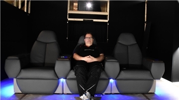 Ein Mann sitzt in einem buntbeleuchteten Kino.