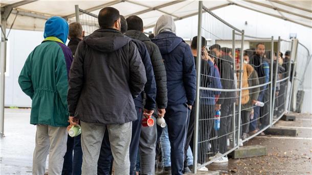 In einer Landeserstaufnahmestelle in Baden-Württemberg warten Flüchtlinge in einer Schlange vor der Essensausgabe.