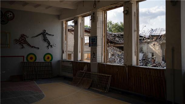 In Kupjansk ist durch die zerbrochenen Fenster einer Turnhalle die zerstörte Bibliothek einer Schule zu sehen.