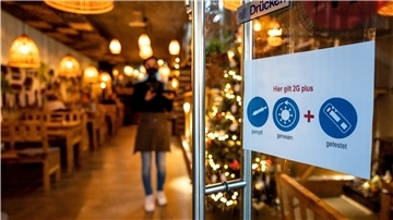 Ein Schild an der Tür eines Restaurants weist auf die 2G-Plus-Regel hin.