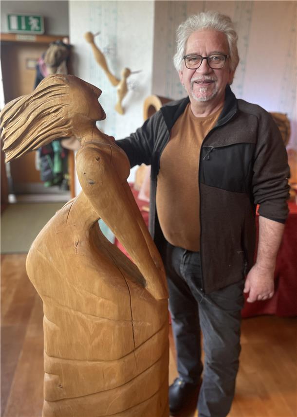 „Skulp(T)our“ in Stollhamm: Wo eine Kettensäge Holz in Kunst verwandelt Mann mit Holzfigur. Ein Künstler schnitzt seine Figuren mit einer Kettensäge.