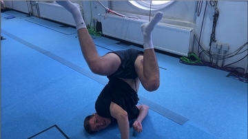 Ein Mann macht einen Kopfstand im Workshop für das Musical-Tarzan.