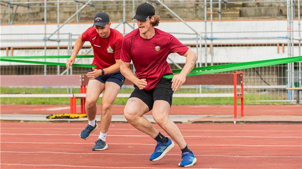 Zwei Sportler laufen gegen den Zug eines Gummibandes an. Die Pinguins-Spieler Rayan Bettahar (v. l.) und Leon Hungerecker beim Sommertraining.