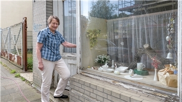 Ingrid Riedel steht an der Weidestraße Geestemünde vor dem alten Schaufenster aus den 50er Jahren, in dem sie ihre Porzellanmalerei ausgestellt hatte. 