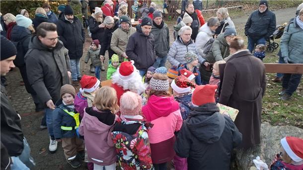 Kinder umringen einen Weihnachtsmarktstand. 