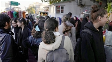 Iranische Frauen gehen ohne ihr vorgeschriebenes islamisches Kopftuch zu tragen durch Teheran.