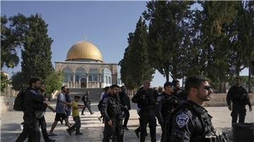 Israelische Polizisten eskortieren eine Gruppe jüdischer Männer zum Tempelberg in der Altstadt von Jerusalem - im Hintergrund die Al-Aqsa-Moschee.