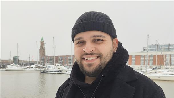 Ein Mann mit Mütze steht am Neuen Hafen