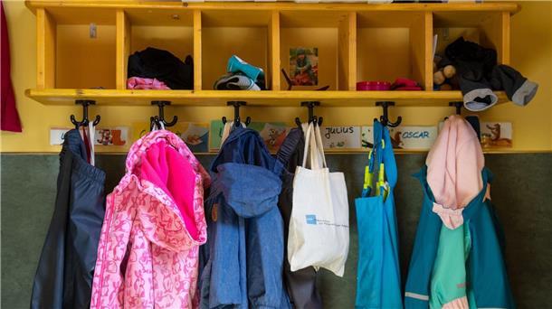 Deutlich mehr pädagogisches Personal in Kindergärten Jacken im Eingangsbereich eines Kindergartens