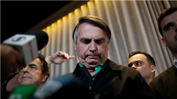 Jair Bolsonaro, ehemaliger Präsident von Brasilien, umgeben von Journalisten in einem Restaurant in Belo Horizonte.