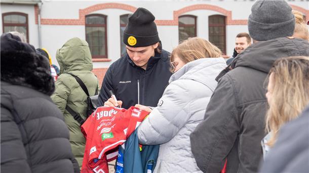 Jake Virtanen unterschreibt auf einem Trikot.
