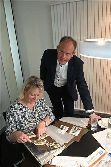 Jan Mackenberg und Birgit Asmann freuen sich auf das Jubiläum der Volksbank Bremervörde. Beim Blick ins Album mit historischen Fotos wird die 100-jährige Geschichte der Genossenschaftsbank lebendig.
