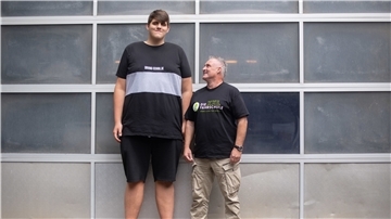 Jannik Könecke (l) und Jörg Vespermann, Fahrlehrer und Geschäftsführer Berufskraftfahrer-Akademie-Nord GmbH, stehen vor einem Garagentor.