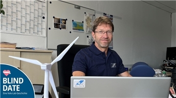 Ein Mann sitzt an einem Schreibtisch in einem Büro.