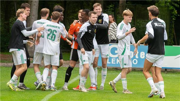 Heeslinger SC behält im Elfmeter-Schießen die Nerven Männer in Sporttrikots stehen auf einem Rasen.