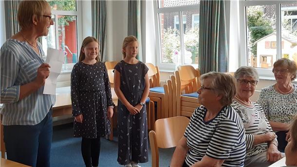 Jette Bammann und Marie Holsten tragen beim gemütlichen Nachmittag des DRK-Ortsvereins ein Gedicht vor.
