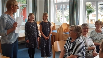 Jette Bammann und Marie Holsten tragen beim gemütlichen Nachmittag des DRK-Ortsvereins ein Gedicht vor.